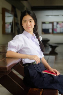 Taylandlı liseli üniformasının portresi. Genç güzel kız mutlu ve rahat.