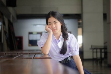 Taylandlı liseli üniformasının portresi. Genç güzel kız mutlu ve rahat.