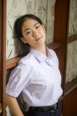 Taylandlı liseli üniformasının portresi. Genç güzel kız mutlu ve rahat.