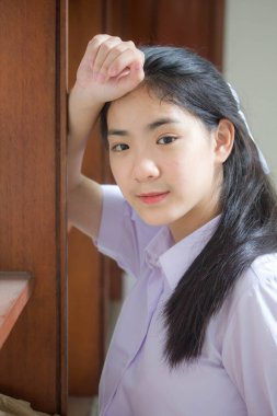 Taylandlı liseli üniformasının portresi. Genç güzel kız mutlu ve rahat.