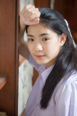 Taylandlı liseli üniformasının portresi. Genç güzel kız mutlu ve rahat.