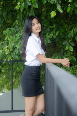 Taylandlı yetişkin öğrenci üniforması portresi. Güzel kız rahatla ve gülümse.