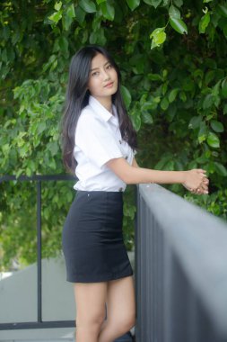 Taylandlı yetişkin öğrenci üniforması portresi. Güzel kız rahatla ve gülümse.