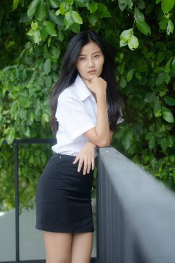 Taylandlı yetişkin öğrenci üniforması portresi. Güzel kız rahatla ve gülümse.