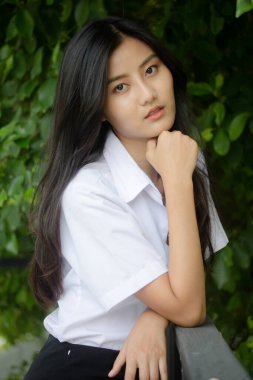 Taylandlı yetişkin öğrenci üniforması portresi. Güzel kız rahatla ve gülümse.