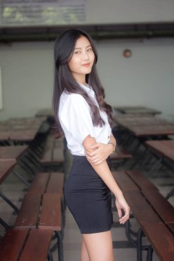 Taylandlı yetişkin öğrenci üniforması portresi. Güzel kız rahatla ve gülümse.