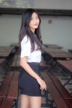 Taylandlı yetişkin öğrenci üniforması portresi. Güzel kız rahatla ve gülümse.