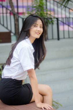 Taylandlı yetişkin öğrenci üniforması portresi. Güzel kız rahatla ve gülümse.