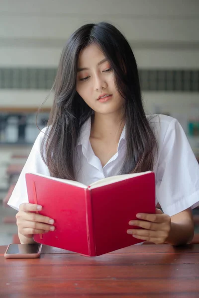 泰族成人大学生校服的肖像美女读红皮书 — 图库照片