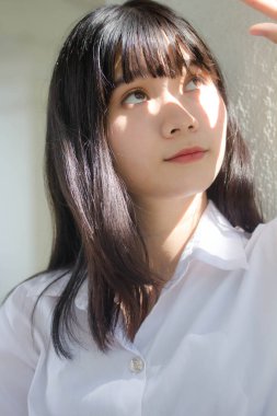 Taylandlı yetişkin öğrenci üniforması portresi. Güzel kız rahatla ve gülümse.