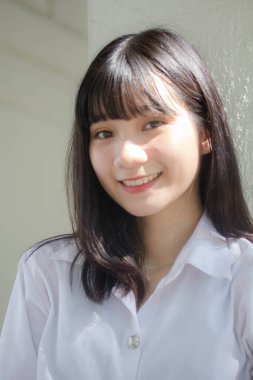 Taylandlı yetişkin öğrenci üniforması portresi. Güzel kız rahatla ve gülümse.