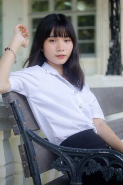 Taylandlı yetişkin öğrenci üniforması portresi. Güzel kız rahatla ve gülümse.