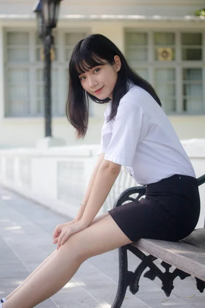 Taylandlı yetişkin öğrenci üniforması portresi. Güzel kız rahatla ve gülümse.