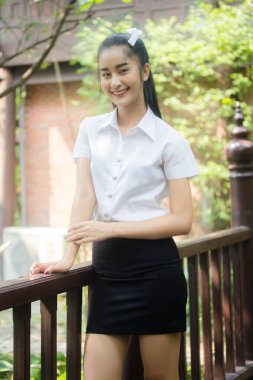 Taylandlı yetişkin öğrenci üniforması portresi. Güzel kız rahatla ve gülümse.