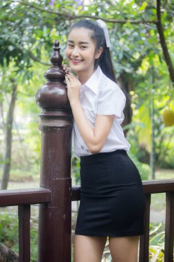 Taylandlı yetişkin öğrenci üniforması portresi. Güzel kız rahatla ve gülümse.