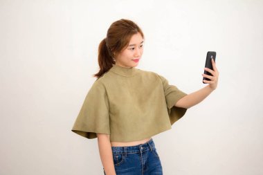 Tayland portresi. Yetişkin güzel bir kız. Akıllı telefonuyla selfie çekiyor.