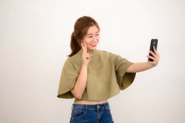 Tayland portresi. Yetişkin güzel bir kız. Akıllı telefonuyla selfie çekiyor.
