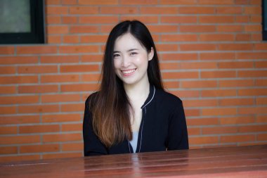 Taylandlı yetişkin öğrenci üniforması portresi. Güzel kız rahatla ve gülümse.