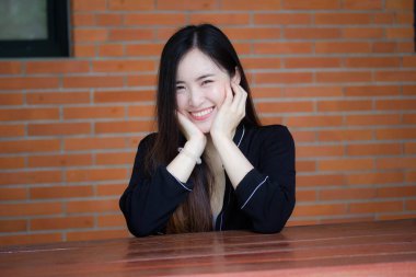 Taylandlı yetişkin öğrenci üniforması portresi. Güzel kız rahatla ve gülümse.