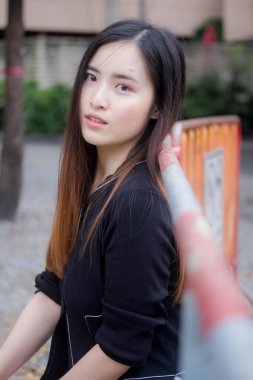 Taylandlı yetişkin öğrenci üniforması portresi. Güzel kız rahatla ve gülümse.