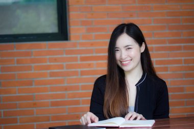 Taylandlı yetişkin öğrenci üniforması portresi. Güzel kız kırmızı kitabı okudu.