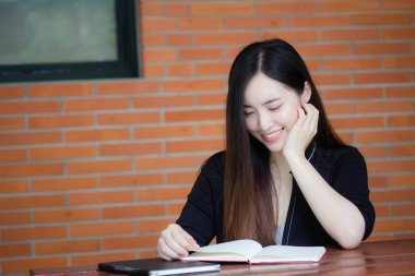 Taylandlı yetişkin öğrenci üniforması portresi. Güzel kız kırmızı kitabı okudu.