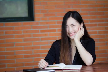 Taylandlı yetişkin öğrenci üniforması portresi. Güzel kız kırmızı kitabı okudu.