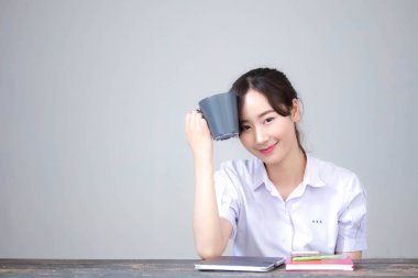 Asya Taylandlı lise öğrencisi üniforması. Güzel kız kahve içiyor.