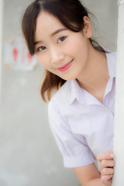 Taylandlı liseli üniformasının portresi. Genç güzel kız mutlu ve rahat.