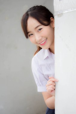 Taylandlı liseli üniformasının portresi. Genç güzel kız mutlu ve rahat.