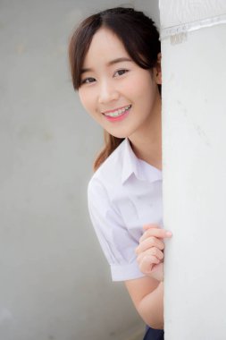 Taylandlı liseli üniformasının portresi. Genç güzel kız mutlu ve rahat.