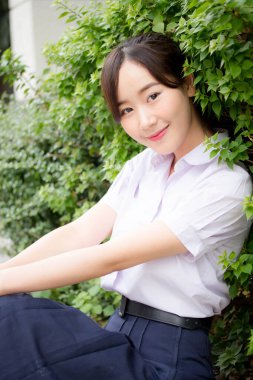 Taylandlı liseli üniformasının portresi. Genç güzel kız mutlu ve rahat.