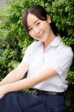 Taylandlı liseli üniformasının portresi. Genç güzel kız mutlu ve rahat.