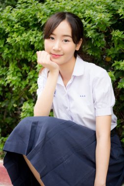 Taylandlı liseli üniformasının portresi. Genç güzel kız mutlu ve rahat.