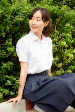 Taylandlı liseli üniformasının portresi. Genç güzel kız mutlu ve rahat.