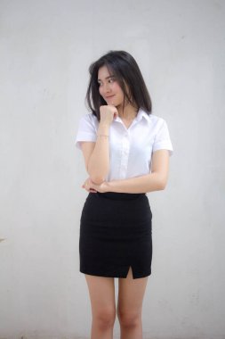 Taylandlı yetişkin öğrenci üniforması portresi. Güzel kız rahatla ve gülümse.