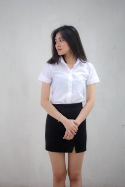 Taylandlı yetişkin öğrenci üniforması portresi. Güzel kız rahatla ve gülümse.