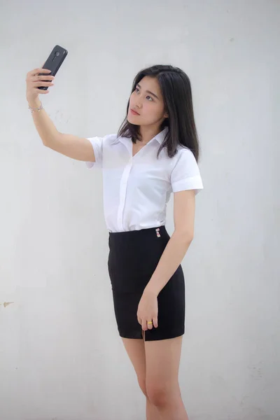 자신의 스마트폰 셀피를 사용하는 타이성 대학생 유니폼을 아름다운 소녀의 — 스톡 사진