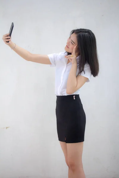 タイのポートレート大人学生大学制服美しいです女の子使用して彼女のスマートフォンSelfie — ストック写真