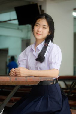 Taylandlı liseli üniformasının portresi. Genç güzel kız mutlu ve rahat.