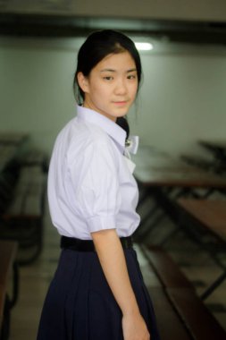 Taylandlı liseli üniformasının portresi. Genç güzel kız mutlu ve rahat.