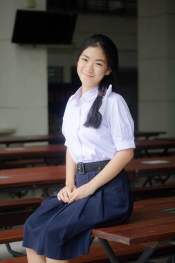 Taylandlı liseli üniformasının portresi. Genç güzel kız mutlu ve rahat.