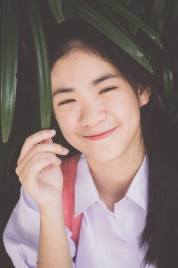 Taylandlı liseli üniformasının portresi. Genç güzel kız mutlu ve rahat.