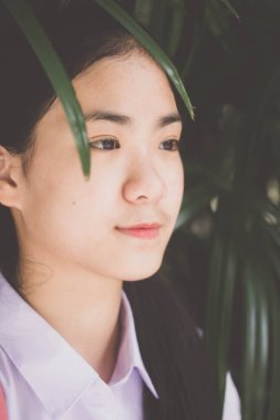 Taylandlı liseli üniformasının portresi. Genç güzel kız mutlu ve rahat.