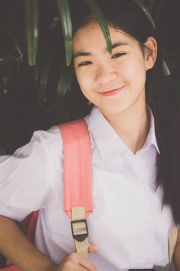 Taylandlı liseli üniformasının portresi. Genç güzel kız mutlu ve rahat.