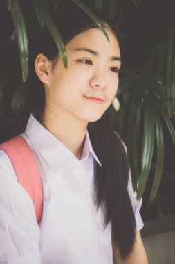 Taylandlı liseli üniformasının portresi. Genç güzel kız mutlu ve rahat.