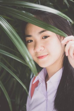 Taylandlı liseli üniformasının portresi. Genç güzel kız mutlu ve rahat.