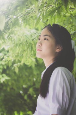 Taylandlı liseli üniformasının portresi. Genç güzel kız mutlu ve rahat.