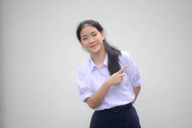 Taylandlı liseli üniformasının portresi. Güzel bir kız işaret ediyor.