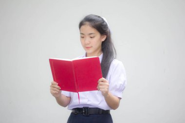 Asya Taylandlı lise öğrencisi üniforması. Güzel kız bir kitap okumuş.